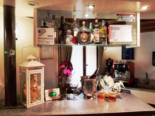 a kitchen counter with bottles of alcohol on a shelf at H O T E L S A N G A L L O l in Venice