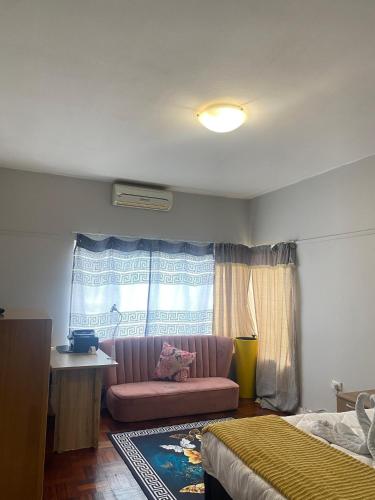 a living room with a pink couch and a window at Wonderful Guest house in Durban