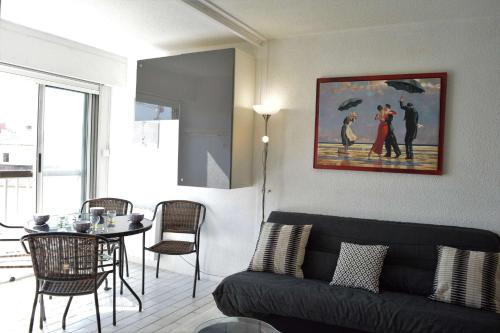 un salon avec un canapé noir et une table dans l'établissement Studio cabine 4 couchages CAP D'AGDE CT005-031, au Cap d'Agde