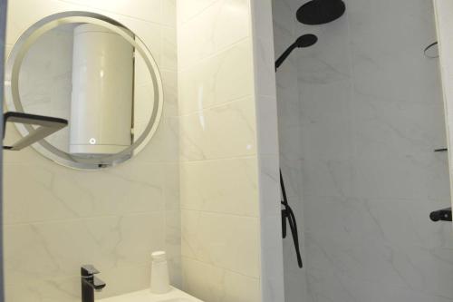 une salle de bain blanche avec un miroir et un lavabo dans l'établissement Studio cabine 4 couchages CAP D'AGDE CT005-031, au Cap d'Agde