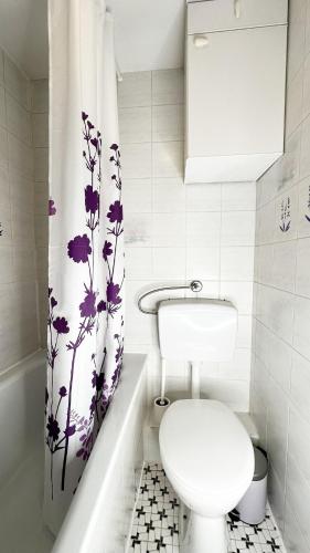a bathroom with a toilet and a shower curtain at Maison Provençale in Bremen