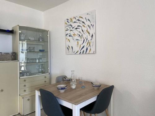 une table de salle à manger avec des chaises et un tableau au mur dans l'établissement Appartement 2 pièces cabine CAP D'AGDE CT030-196, au Cap d'Agde