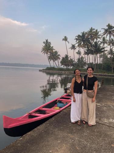two women standing next to a boat on the water at Munroe Heritage Inn in Munroe Island