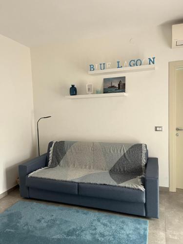 a blue couch in a living room with a shelf at Blue Lagoon Home in Sulzano