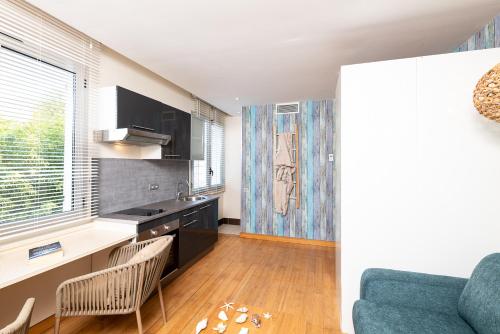 Il comprend une cuisine et un salon doté d'un canapé bleu. dans l'établissement Studio Meublé Mandara Beach Bungalow - Antibes - Juan-les-Pins - French Riviera, à Juan-les-Pins