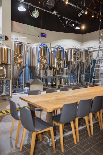 a room with a wooden table and chairs andbeer tanks at Holiday Inn Express - Hamburg South A7-AS42 by IHG in Egestorf