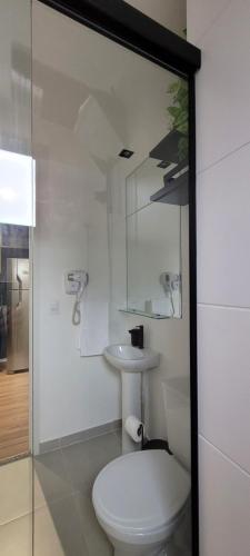 a white bathroom with a toilet and a sink at STUDIO104 - Novo e completo na melhor localização de Pinheiros, próximo ao Metrô Fradique Coutinho in Sao Paulo