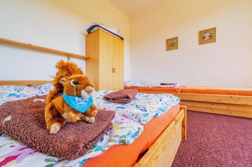 a stuffed animal is sitting on a bed at Penzion Šumavous in Vimperk