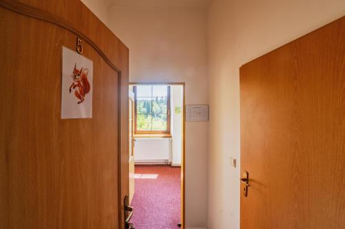 an empty hallway with a door and a window at Penzion Šumavous in Vimperk