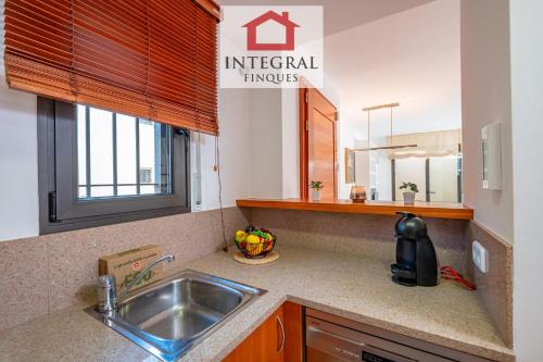 a kitchen counter with a sink and a window at Ca la Blava Palamós in Palamós