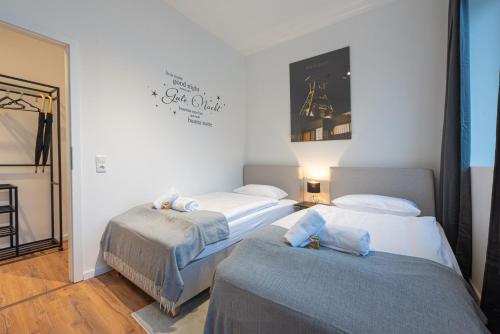 a room with three beds and a sign on the wall at Neues und zentrales Apartment im Ruhrgebiets-Style von STAY YOUR WAY in Essen