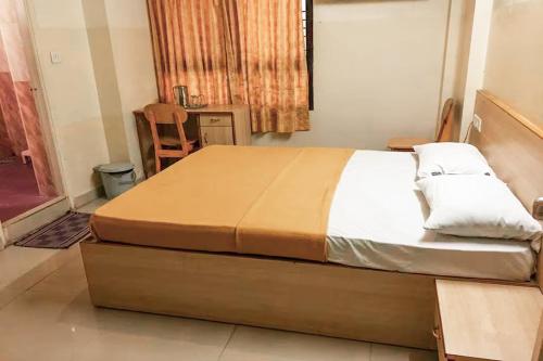 a bedroom with a large bed in a room at Hotel Rainbow near Victoria Hospital City Market in Bengaluru