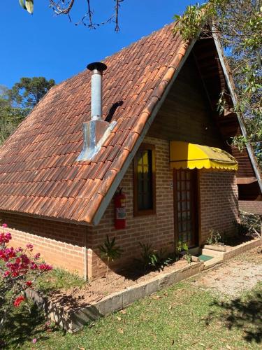a small brick house with a chimney on it at Pousada Sotaque Mineiro in Cunha