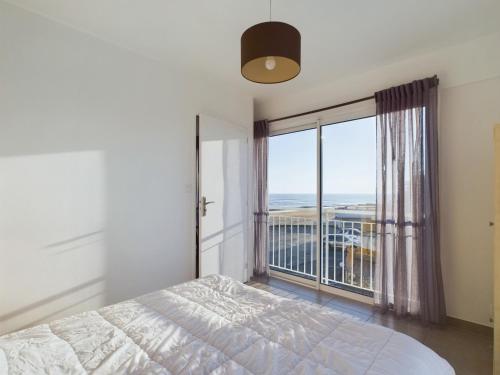 une chambre avec un lit et une grande fenêtre dans l'établissement Au bord de la plage, appartement pour 8, à La Tranche-sur-Mer