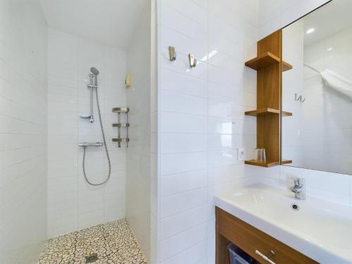une salle de bain blanche avec un lavabo et une douche dans l'établissement Au bord de la plage, appartement pour 8, à La Tranche-sur-Mer