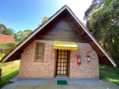 a small brick house with a yellow awning at Pousada Sotaque Mineiro in Cunha