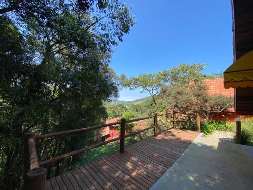 a wooden walkway with a fence and trees at Pousada Sotaque Mineiro in Cunha