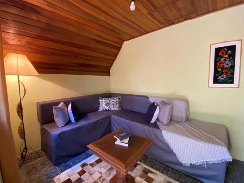 a living room with a blue couch and a table at Pousada Sotaque Mineiro in Cunha