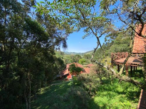 a house in the middle of a field with trees at Pousada Sotaque Mineiro in Cunha