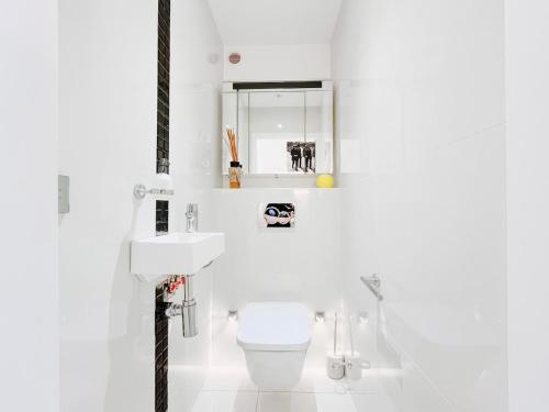 une salle de bain blanche avec des toilettes et un lavabo dans l'établissement Le Lys - Terrasse Cannes, à Cannes