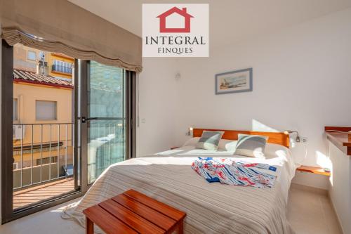 a bedroom with a bed and a large window at Ca la Blava Palamós in Palamós