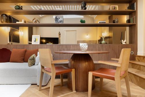 un salon avec une table, des chaises et un canapé dans l'établissement Oniri - Serviced Apartments Eiffel Tower - rue d'Augereau, à Paris