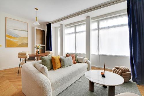 un salon avec un canapé et une table dans l'établissement Oniri - Serviced Apartments Eiffel Tower - rue d'Augereau, à Paris