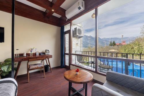 a living room with a view of the mountains at Echor Himalayan Aurum Manali, Heating & Cooling in Manāli