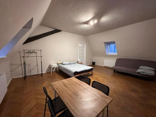 Una sala de estar con una cama, una mesa y sillas. en Apollo 56, en Poznan