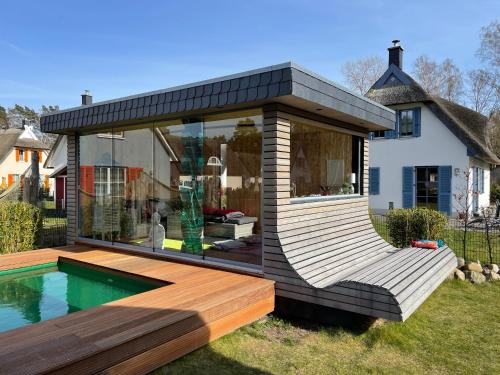 a modern house with a pool and a deck at Ferienhaus Poolhaus in Glowe