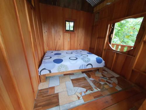 a bed in the inside of a wooden cabin at Digrú Spaa in Pejibaye