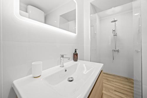 a white bathroom with a sink and a shower at Old Tower Center Apartment 2 in Pula
