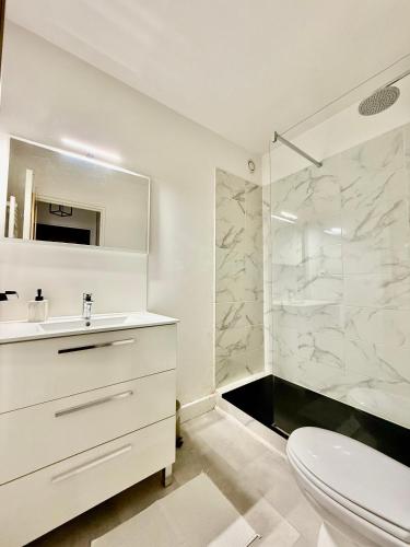 une salle de bain blanche avec un lavabo et une douche dans l'établissement T1 aux pieds de la Gare Bénédictins - DABNB, à Limoges