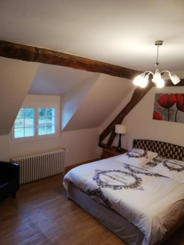 une chambre avec un lit dans un grenier dans l'établissement Domaine de la Ferme de Mont, à Mormant