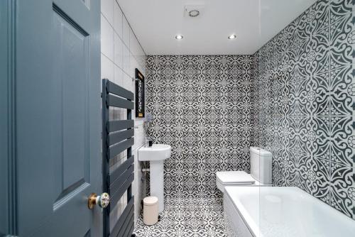 a bathroom with a toilet and a sink and a tub at Moonbeam Cottage - Cosy London Cottage in Eltham