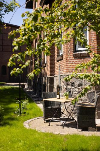 a table and bench in front of a brick building at Oskar & Luise in Krummbek
