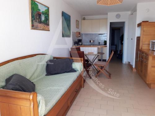 un salon avec un lit et une cuisine dans l'établissement T2 capacite 4 personnes en rez de jardin, à Sète