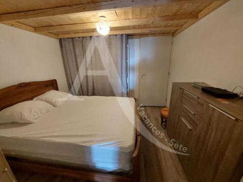 - une petite chambre avec un lit et une commode dans l'établissement T2 capacite 4 personnes en rez de jardin, à Sète