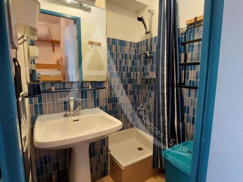 une petite salle de bain avec un lavabo et une douche dans l'établissement T2 capacite 4 personnes en rez de jardin, à Sète