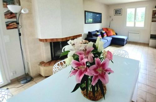 un vase de fleurs sur une table dans le salon dans l'établissement Charmante maison familiale près des plages et du GR 34 pour 8 à 10 personnes Location uniquement à partir de 4 nuitées, à Cancale