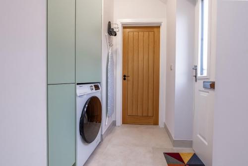 a laundry room with a washer and dryer next to a door at Cosy studio with parking and underfloor heating in Bristol