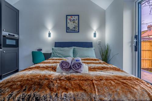 a bedroom with a bed with towels on it at Modern studio w/ underfloor heating & parking in Bristol