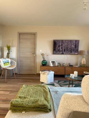 un salon avec un canapé et une table dans l'établissement La Parenthèse vue lac, à Les Grangettes