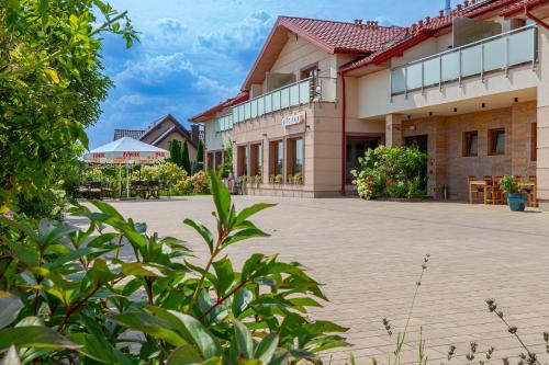 a courtyard of a building with plants in the foreground at Medical Spa Kwiatowa in Łęczyca