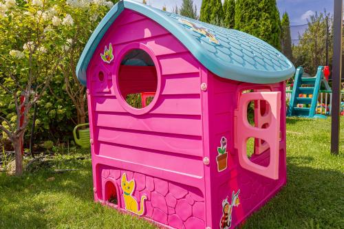 a pink toy dog house in the grass at Medical Spa Kwiatowa in Łęczyca