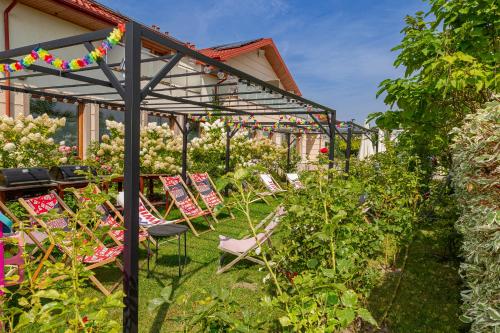 a group of chairs sitting under a pergola in a garden at Medical Spa Kwiatowa in Łęczyca
