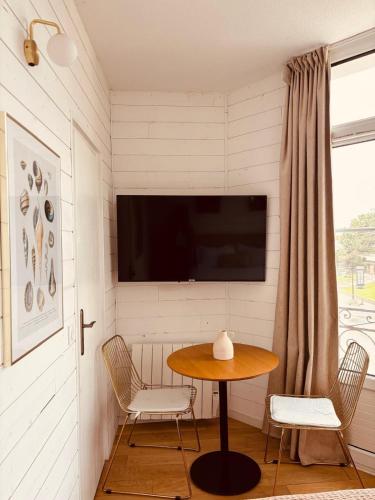 a room with a table and two chairs and a television at Hôtel Le Britannic - centre gare- in Saint Malo