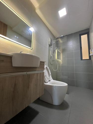 a bathroom with a toilet and a sink and a shower at Jin Lin Homestay 1 in Sibu