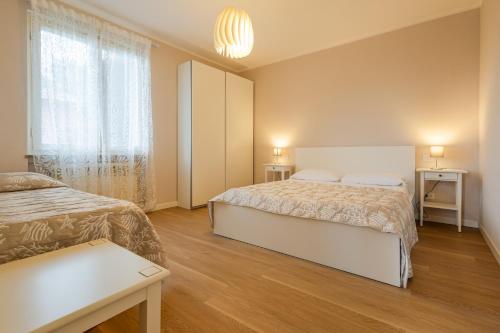 a bedroom with two beds and a window at La Casa di Sara in Pacengo di Lazise