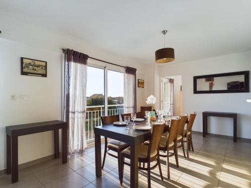 une salle à manger avec une table et des chaises et une fenêtre dans l'établissement Appart 8 personnes - Residence acces a la mer, à La Tranche-sur-Mer